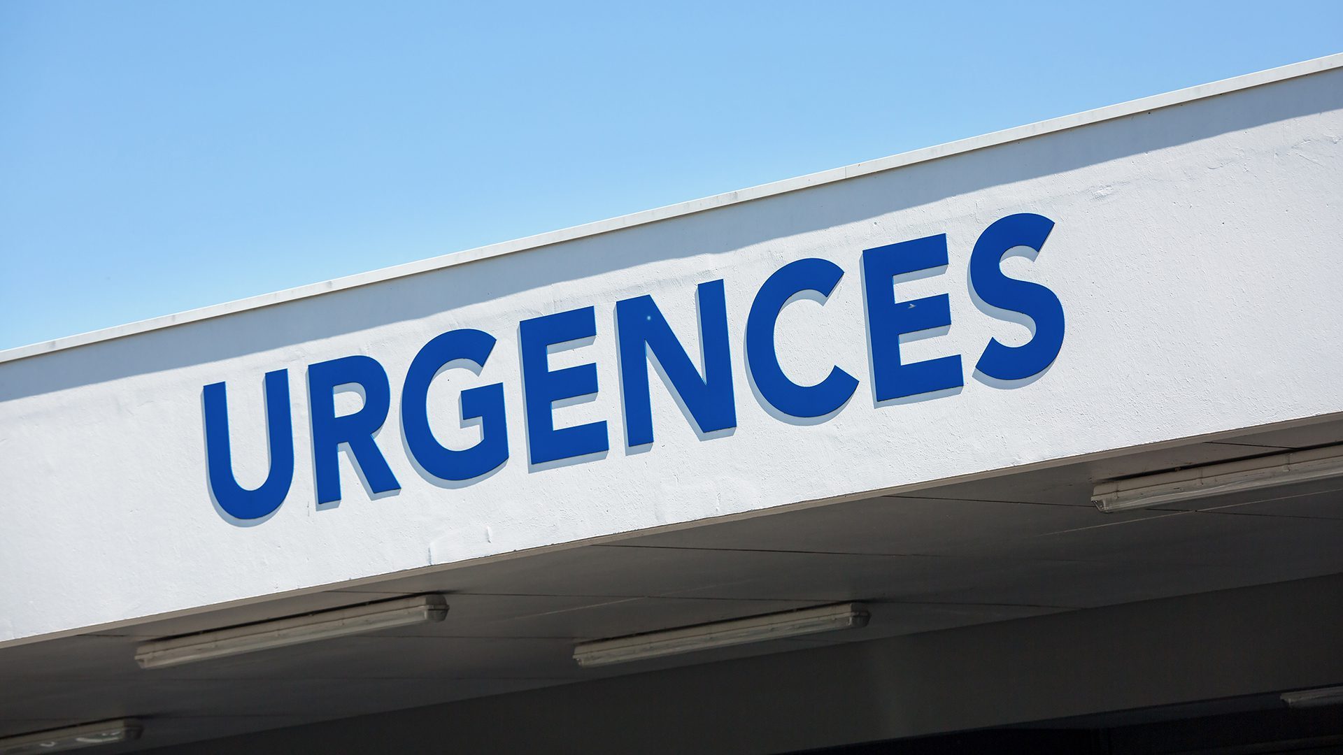 view of Closeup of vertical red sign - "Emergency" ("Urgences" in French).