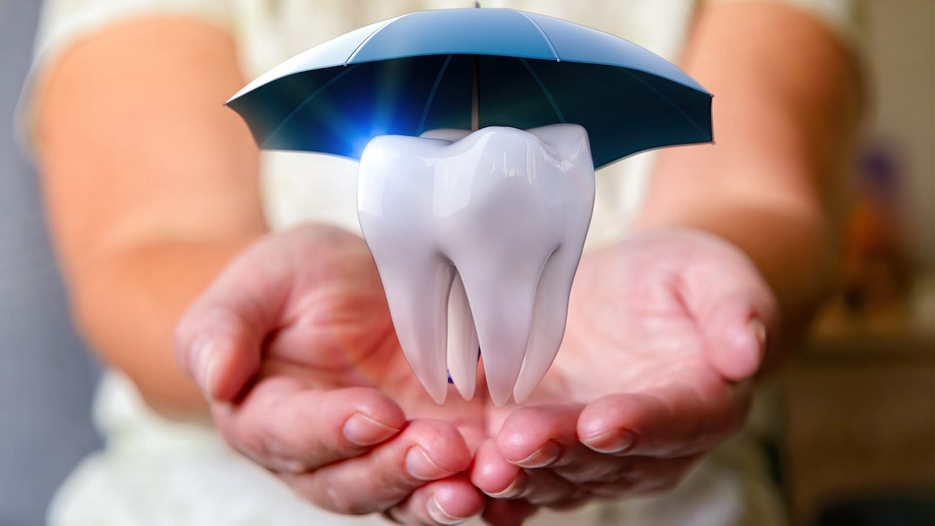 A tooth under an umbrella over woman's hands. Protect health, insurance concept, dental, medical care.